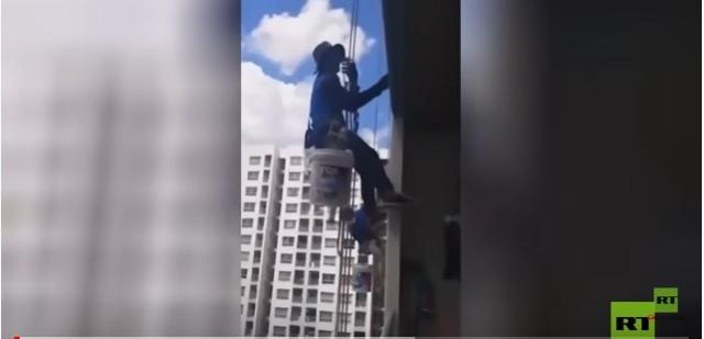 سبب غير متوقع.. سيدة تعلق عمال طلاء في الدور 26