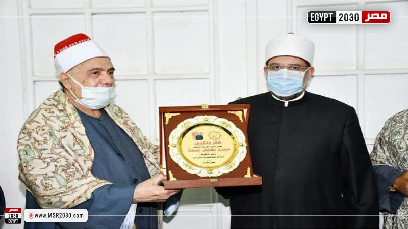 وزير الأاوقاف ونقيب القرَّاء خلال تسلمه الدرع