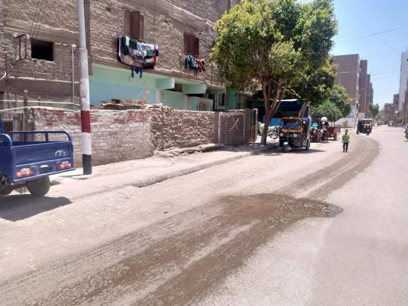 لتخفيف درجات الحرارة والأتربة .. «محلي دشنا» يرش المياه بالشوارع الترابية بالمدينة