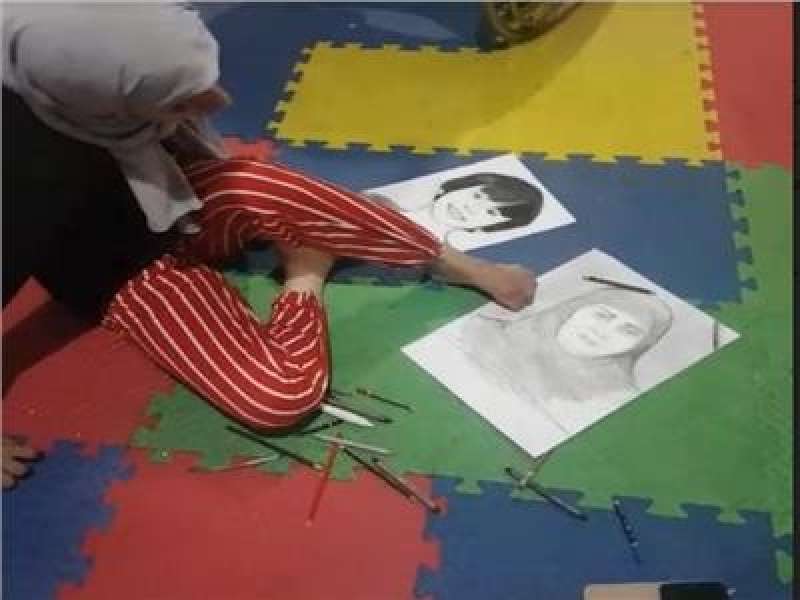 رحمة سراج وهى ترسم بأصابع القدم