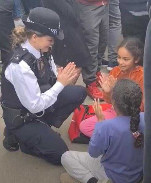 شاهد: شرطية بريطانية تلهو مع الأطفال في انتظار موكب الملكة إليزابيث