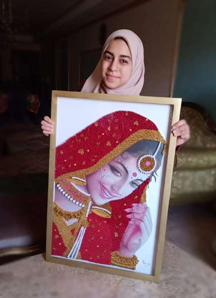 آلاء شرارة مع لوحتها من فن الكولينج