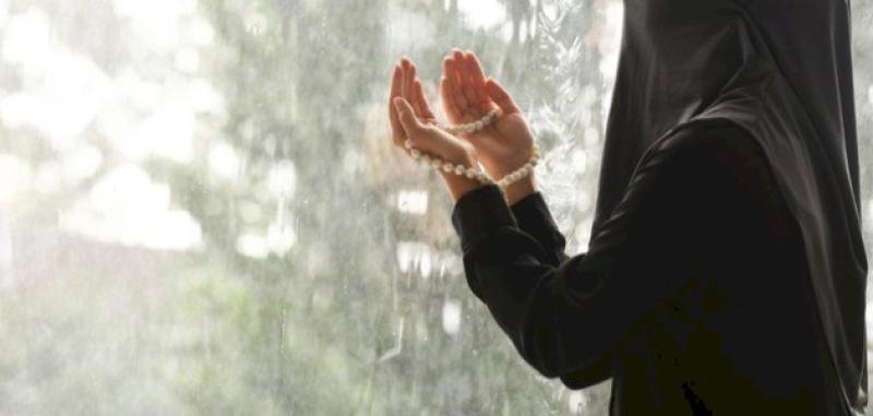 فتاة مسلمة تدعو الله أثناء المطر