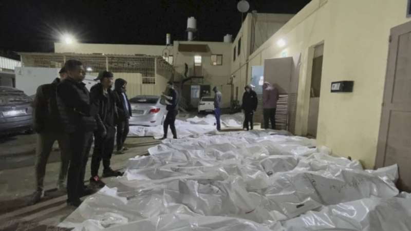 مواطنون ينظرون إلى جثامين في مستشفى الأقصى