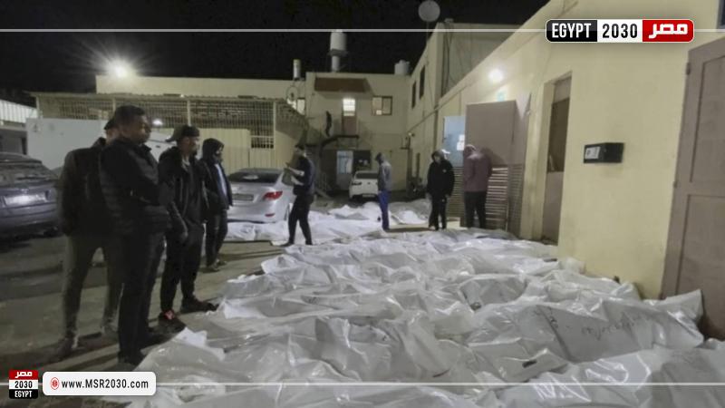 مواطنون ينظرون إلى جثامين في مستشفى الأقصى