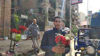 احتفالا بأحد السعف.. أحمد يبيع الورود للأقباط بجوار كنيسة العذراء