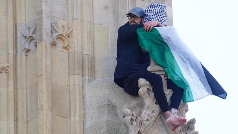 رجل يحمل العلم الفلسطيني يتسلق برج بج بن